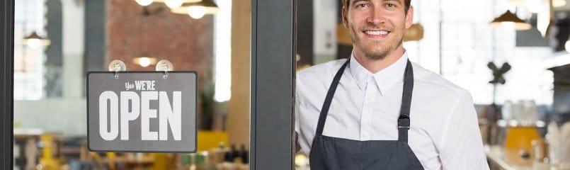 man standing in front of open restaurant sign