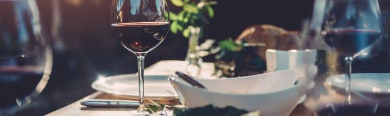 dinner table set for two with full wine glasses