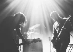 Black and white image of band members on stage playing guitars