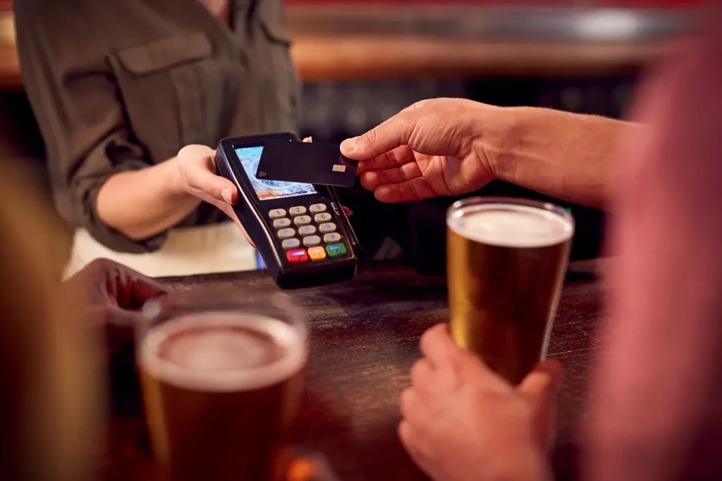 A man paying for a beer with a credit card.