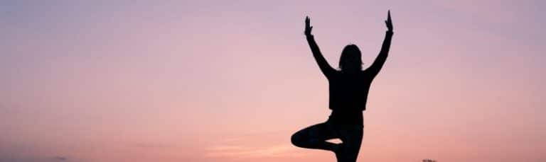 silhouette of woman doing yoga pose