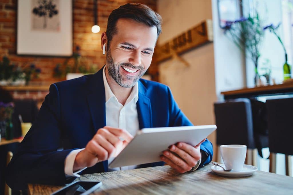 A business professional does research on a tablet in a cafe