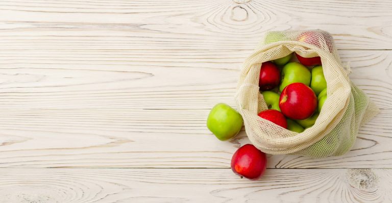 A bag of apples on a table.