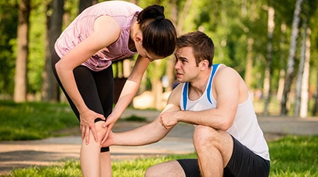 personal trainer assisting client with injury