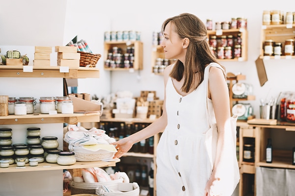 A woman looks through a store filled with products which are insured by beauty product liability insurance and product liability insurance.