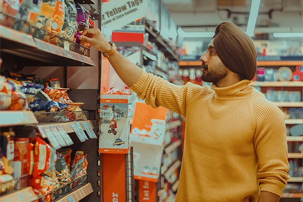 A shopper selects a product at the grocery store.