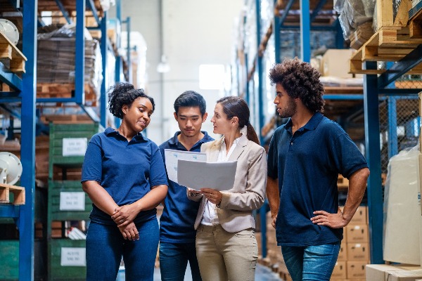 four people walking together in a warehouse