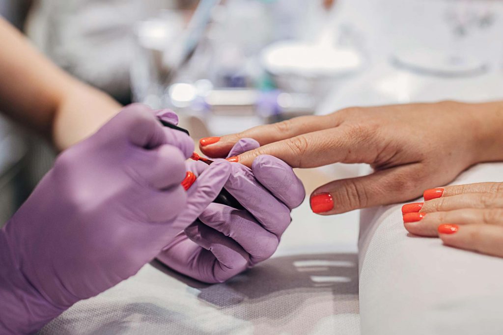 nail tech painting woman's nails