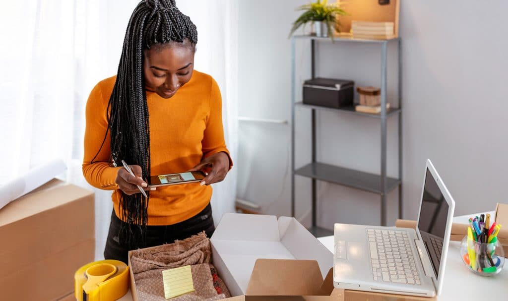 A woman takes a photo of a product to list online for her eBay business that is insured with eBay liability insurance.