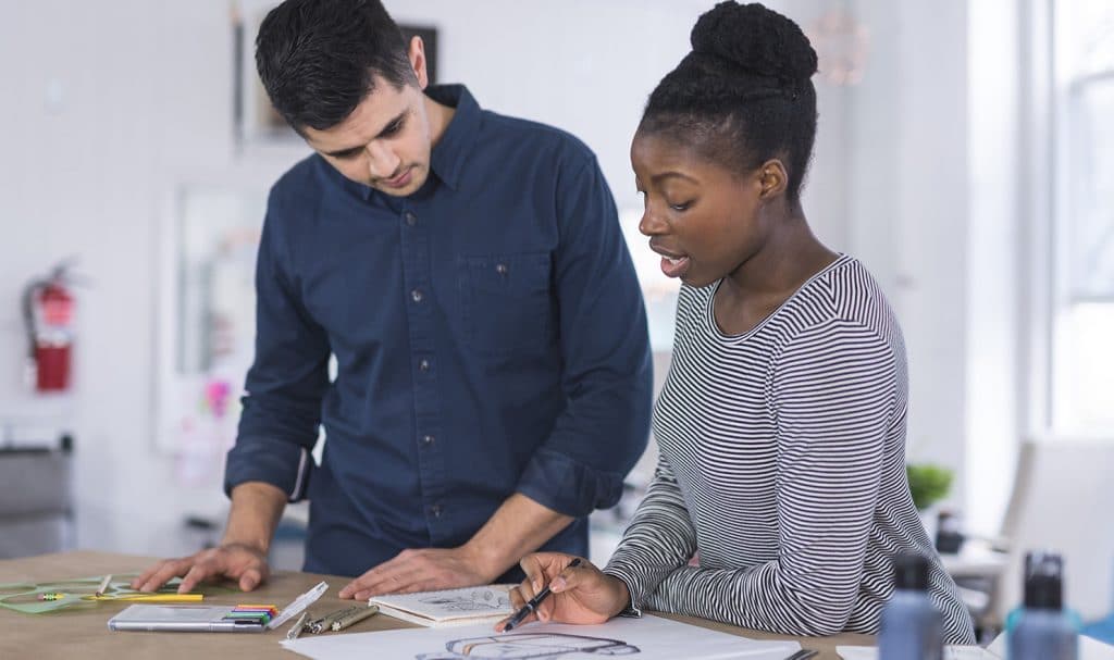 Two people go over product development plans for fixing defects in a product they sell.