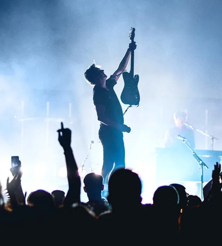 guitarist holding is guitar in the air after finishing a set