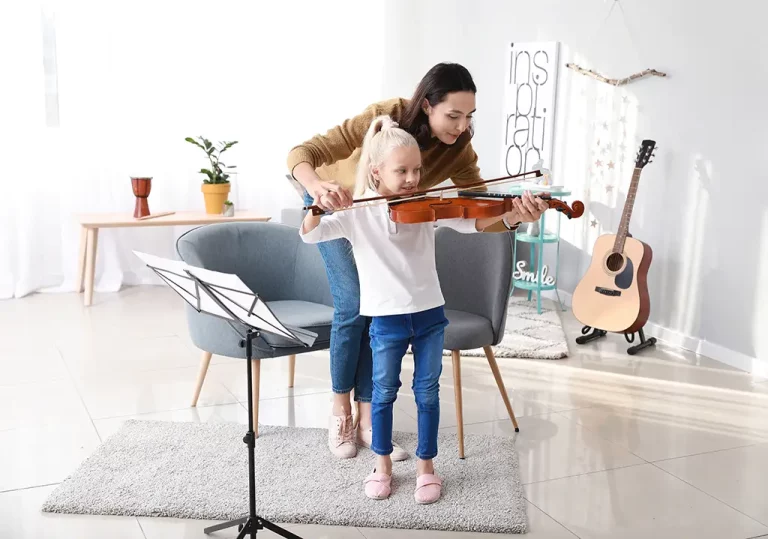 A music teacher specializing in violin helps student in a lesson.