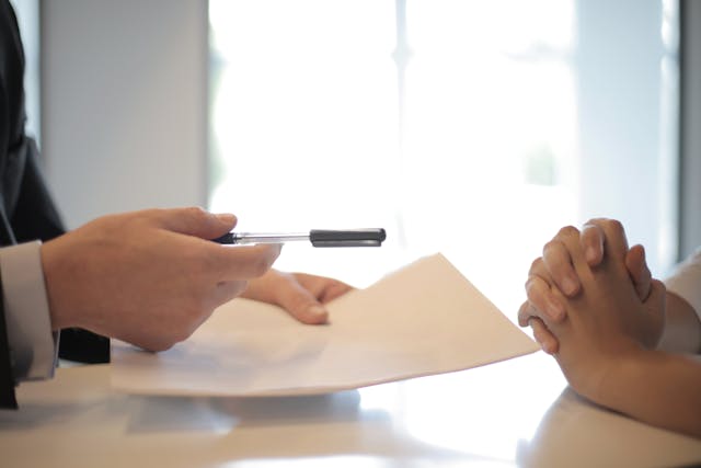 consultant handing client a contract to sign