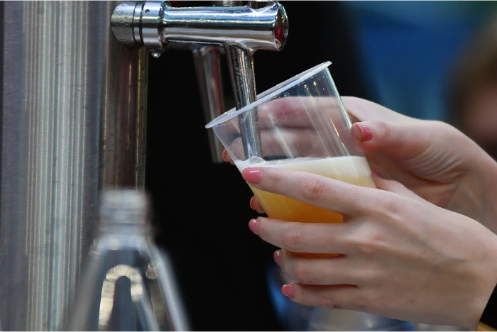 Close up of a woman pouring a beer.