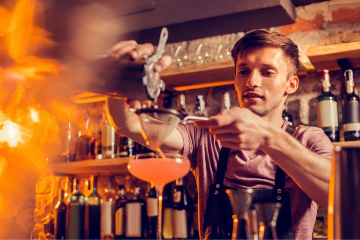 Bartender serving drinks over a martini glass