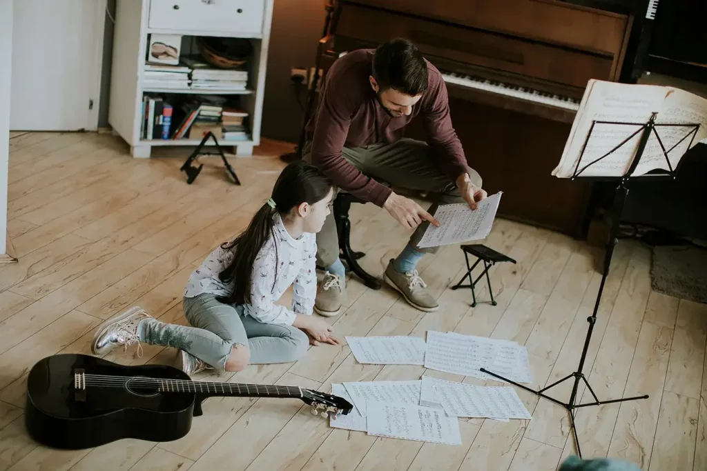 Music teacher with student looking at sheet music