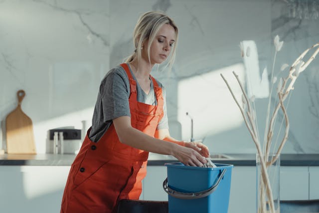 a woman in an orange jumpsuit cleaning