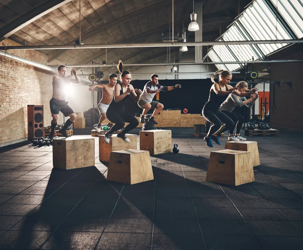 Group fitness class performing box jumps.