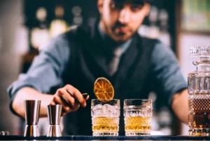 Bartender preparing two cocktails.